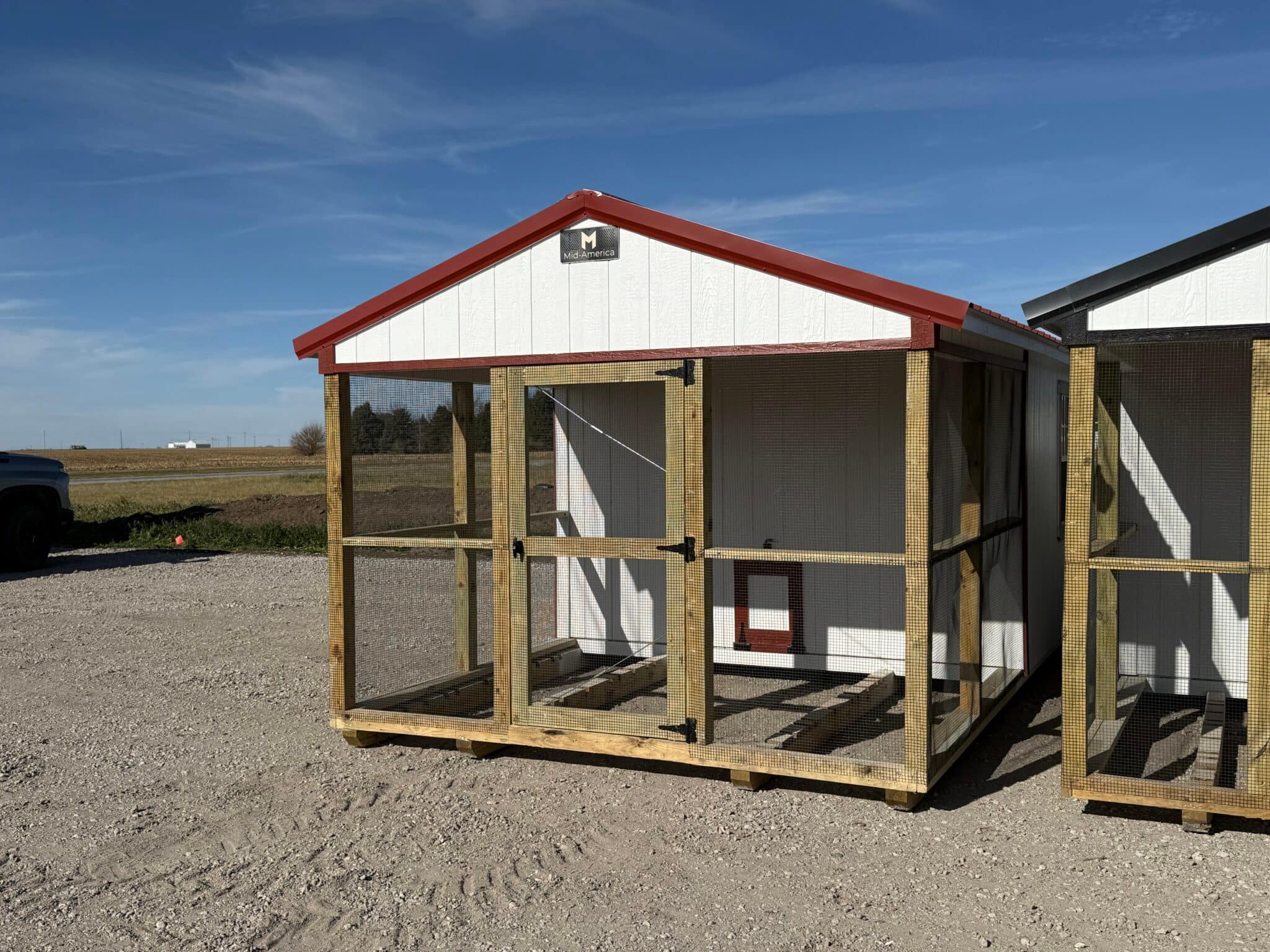 White and red chicken coop with a caged front.