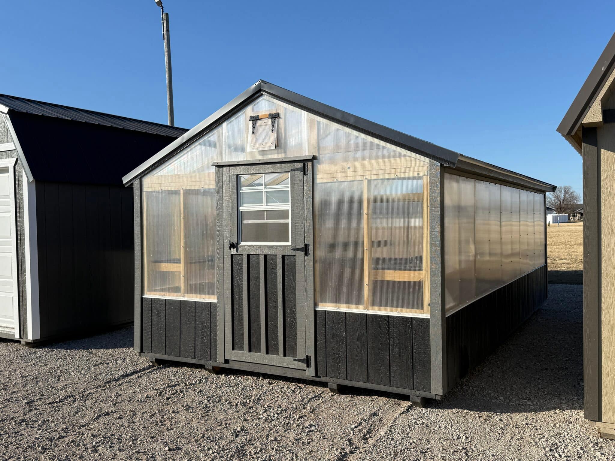 Greenhouse with black accents running around the bottom of the building.