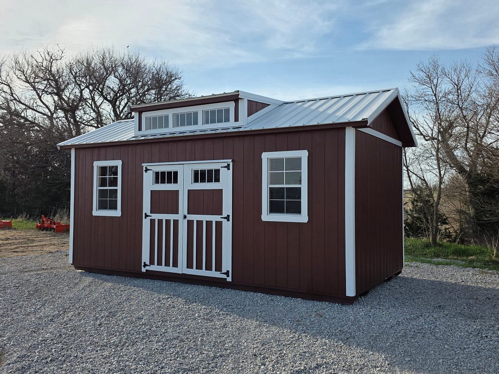 Exterior of an upscale shed, featuring two windows and double doors on the front.