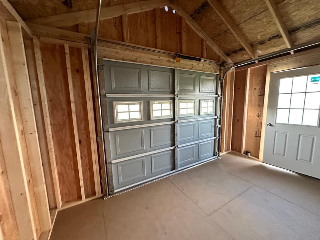 Interior of wood garage building showing garage door.