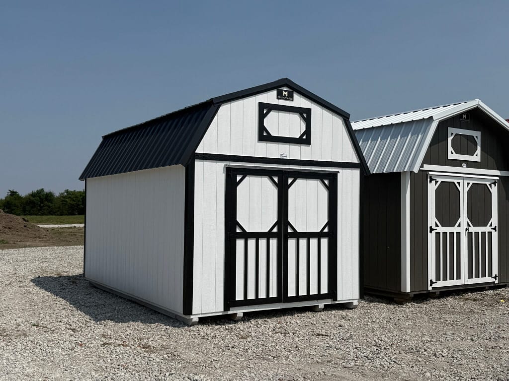 Exterior of a small, barn-styled shed featuring double doors on the front and a small window/vent plate