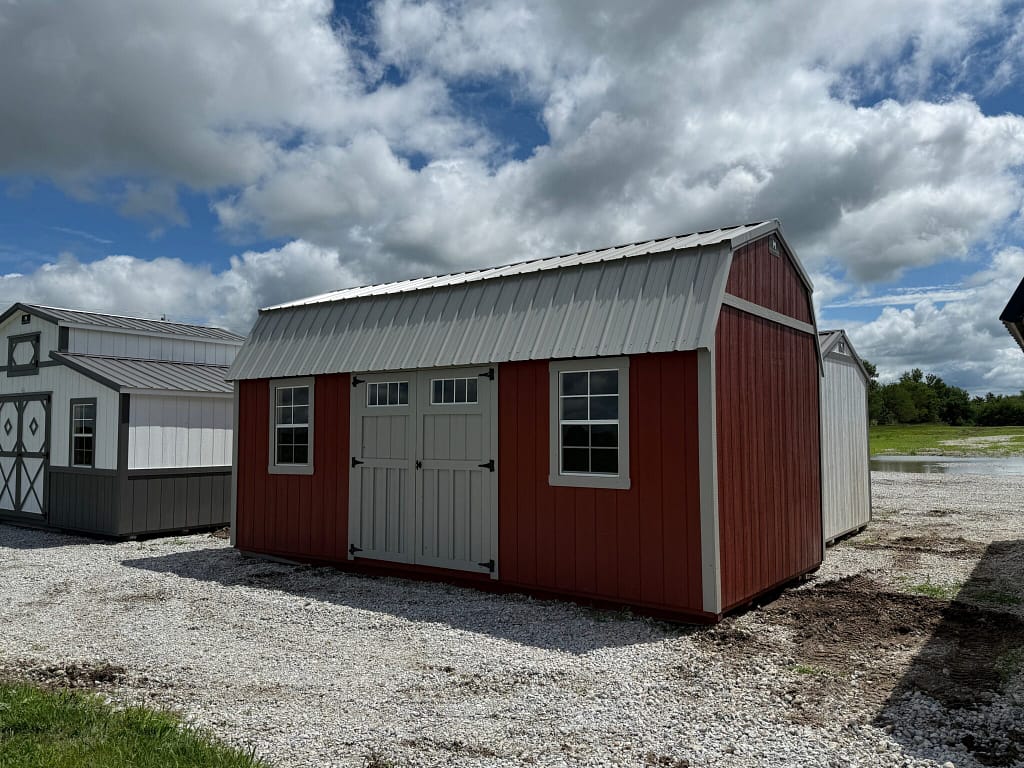Exterior of red and white shed, showcasing shed doors and window.