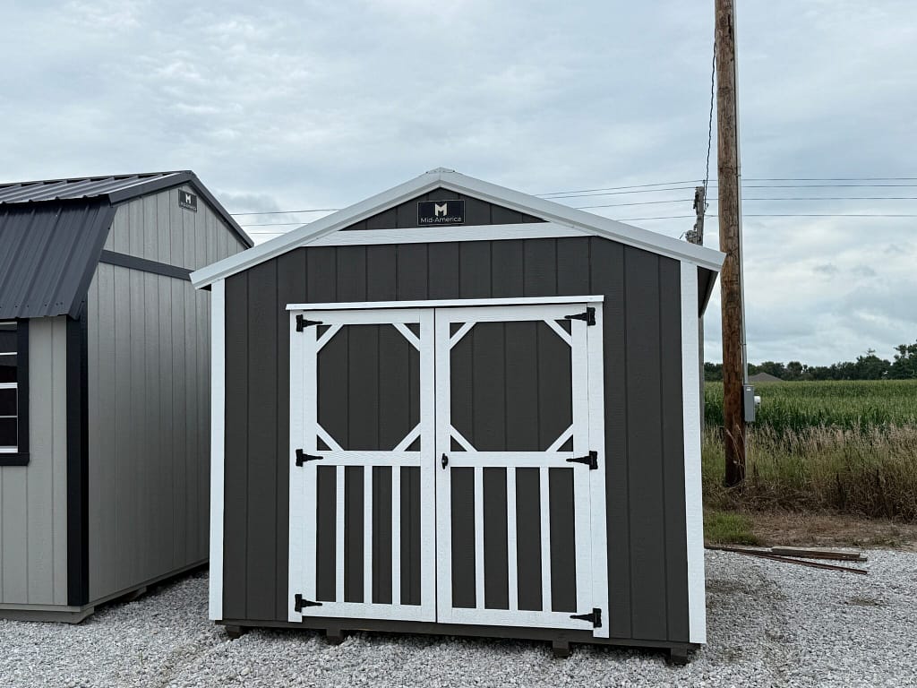 Exterior of dark grey garden shed with white accents.