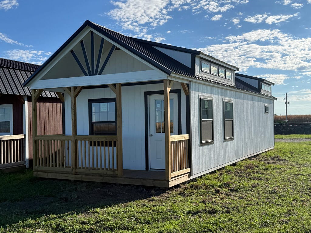 Exterior view of a large, white cabin with a front porch.