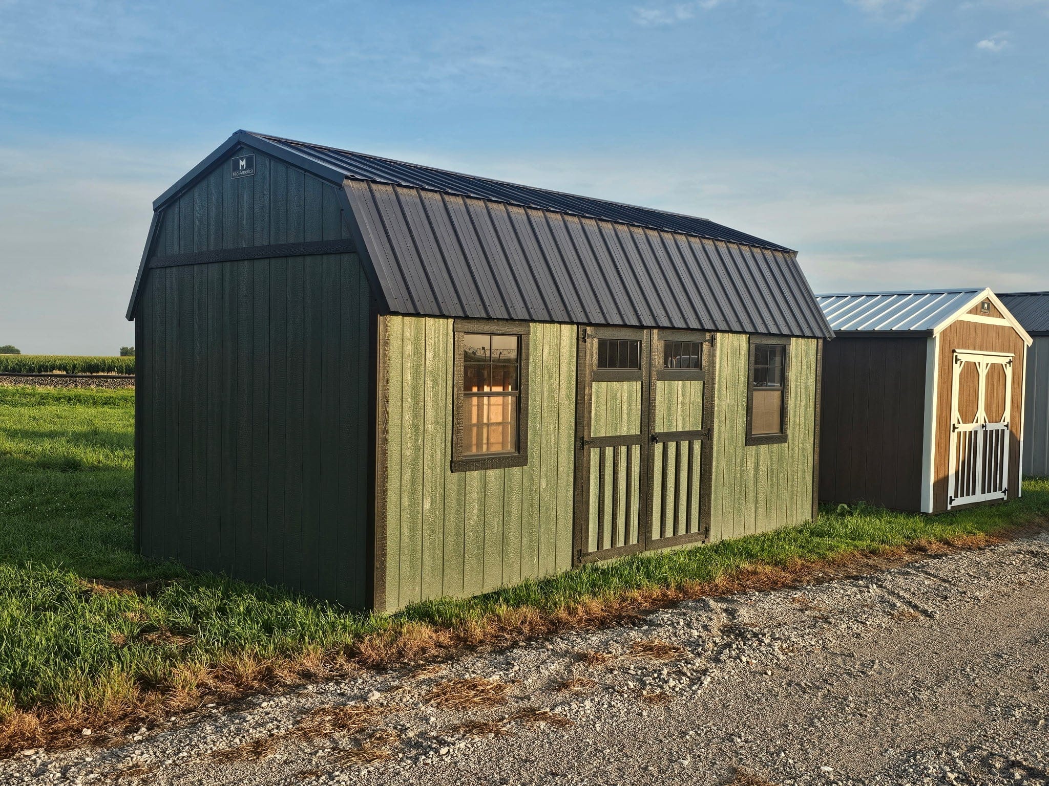 Exterior of green shed showcasing two windows.