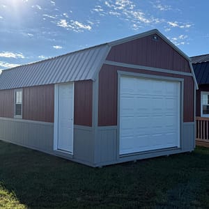 Exterior of large, almost barn-style garage showcasing a car garage door with a side door.