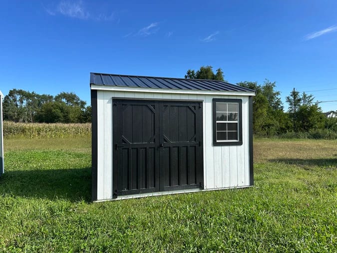 Exterior of white shed with black trim