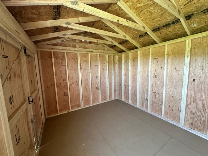 Interior of shed; looking towards back corner, showing the roof trusses above