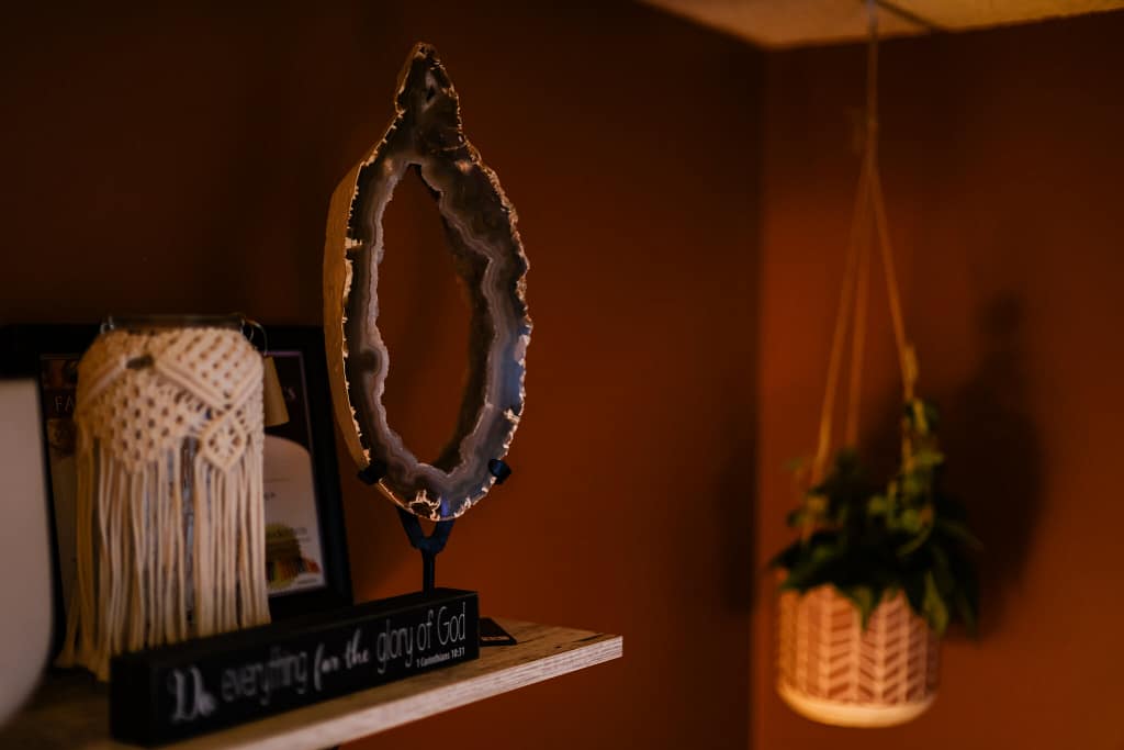 Shelf in Eva's office with geode, plants, and other trinkets.