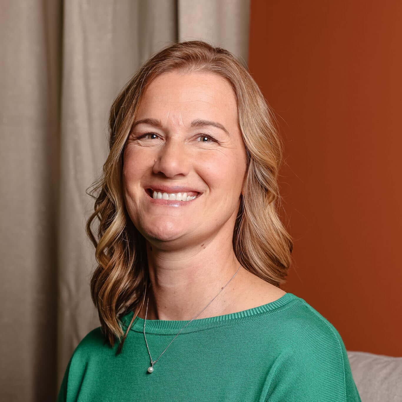 Eva siting in her office in front of a curtain. Eva siting in her office in front of a curtain.