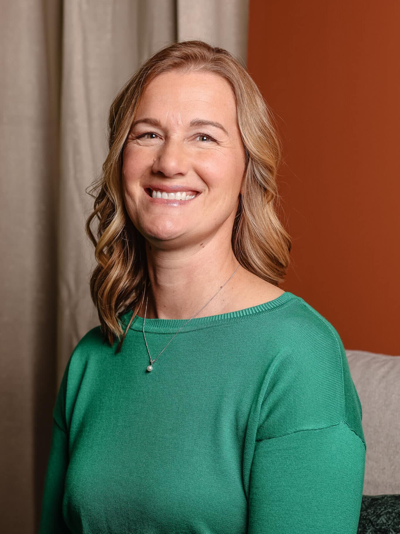 Eva siting in her office in front of a curtain.