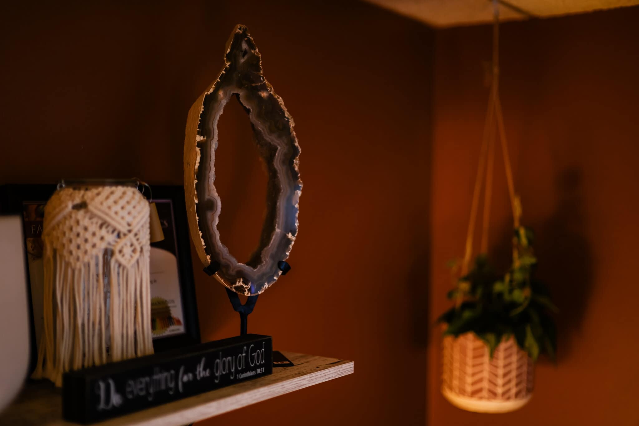 vibrational-auricular-technique Shelf in Eva's office with geode, plants, and other trinkets.